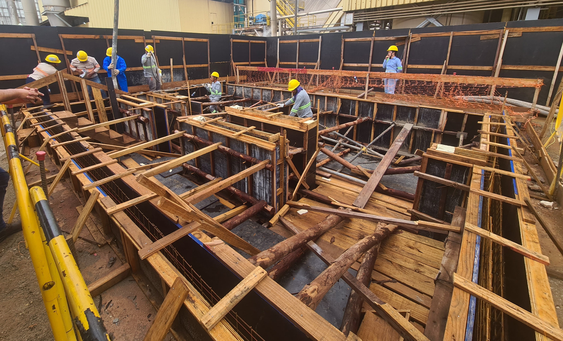 Equipe executando formas e armaduras de vigas baldrame em obra